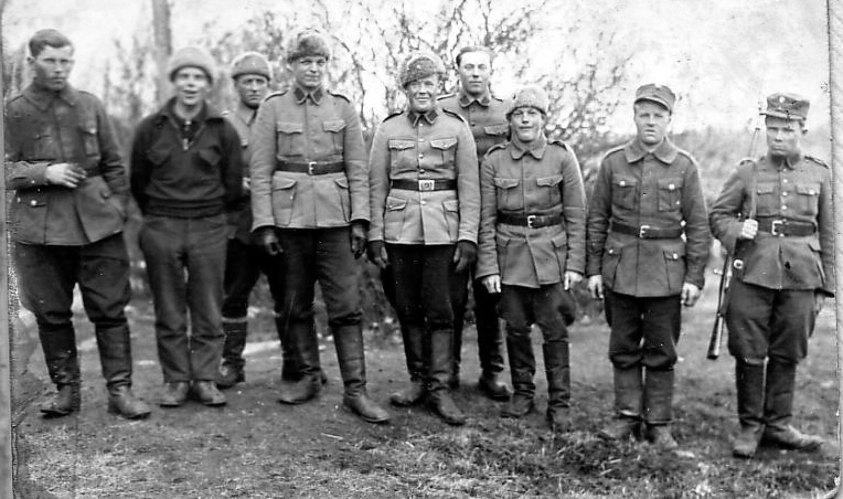 Välirauhan aikainen kuva, jossa Manu on vielä tykistön palveluksessa. Koulutusvaiheessa hän oli ollut Niilo Tarvajärven alaisuudessa.
Ryhmäkuvassa Manu on Haapajärven poikien kanssa, kuva on otettu Toijalassa v. 1940.
Kesän tullessa Manu joutui kiväärikomppaniaan, palveluspaikka muuttui kun komppanioita jaettiin uusiksi ja uusi komppania oli JR 8.
Mustatakkinen nuori mies kuvassa vasemmalla on Matti Junttila, jonka kohtaloksi tuli kaatuminen jatkosodassa. Manu oli tunnistanut hänet tien reunasta marssiessaan Joensuusta itään päin.